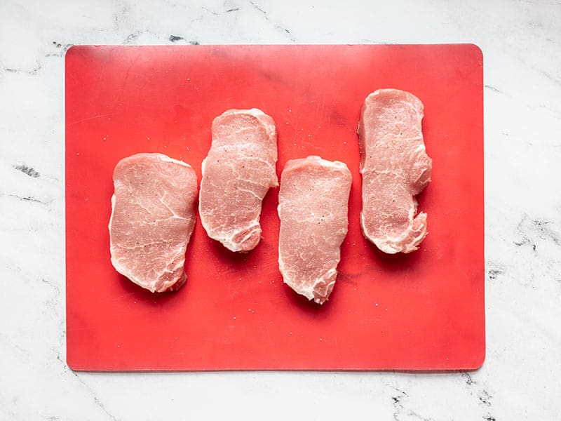 Season center cut pork chops with salt and pepper