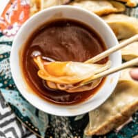 Close up of a dumpling being dipped into a bowl of Simple Sweet and Sour Sauce