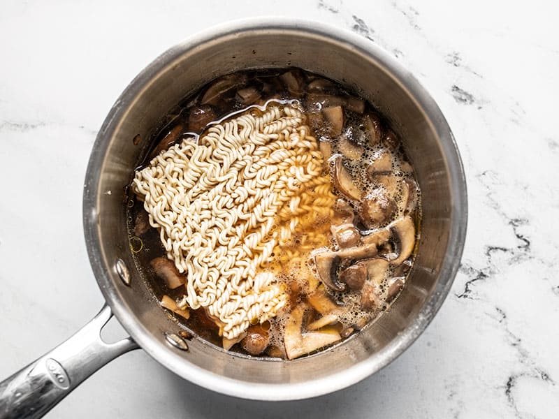 Dry ramen added to the broth in the pot