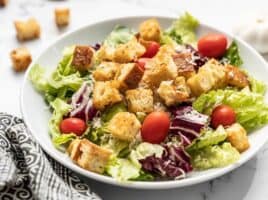 Front view of a large salad in a bowl topped with homemade croutons