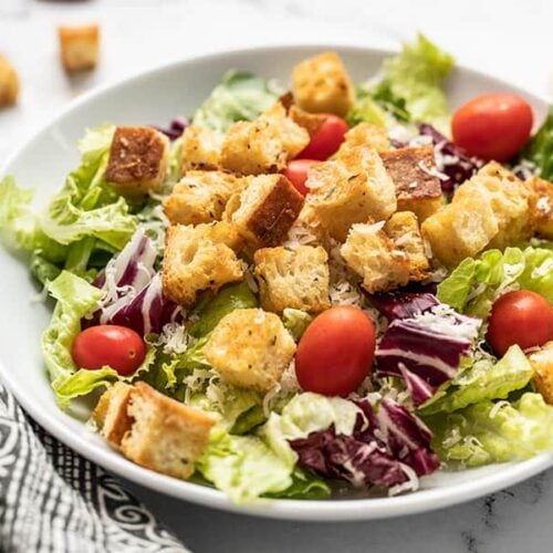 Front view of a large salad in a bowl topped with homemade croutons