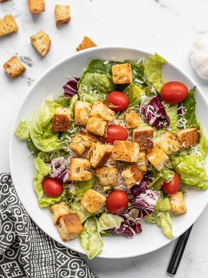 A large salad with romaine, Parmesan, grape tomatoes, and easy baked homemade croutons.