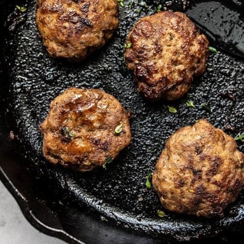 Close up of four Maple Sage Breakfast Sausages in a cast iron skillet