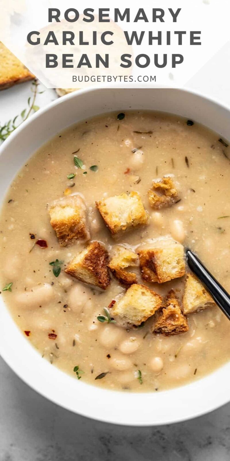 close up of a bowl of white bean soup with croutons