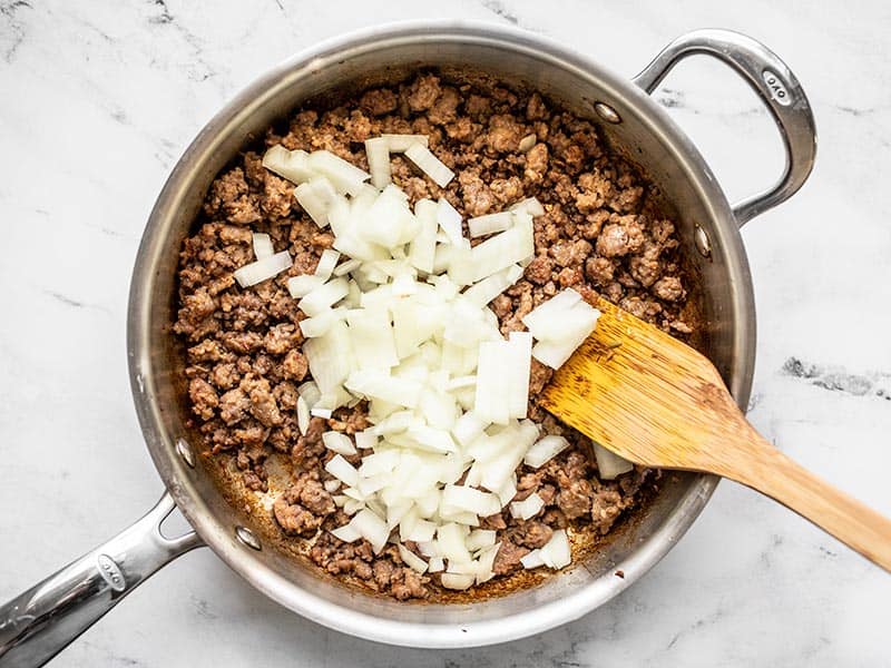 Diced onion added to the skillet with the sausage