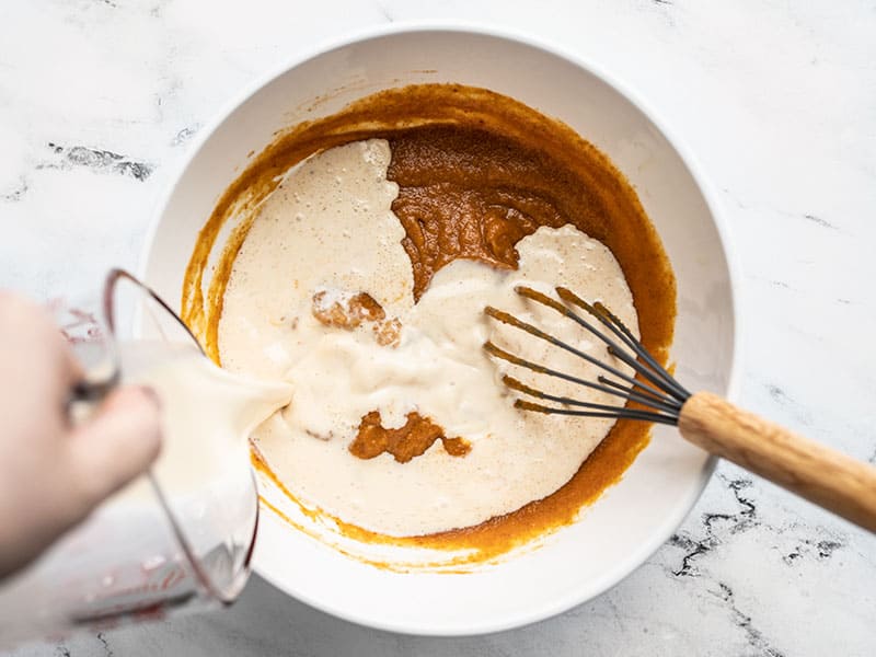 Evaporated milk being poured into the bowl.