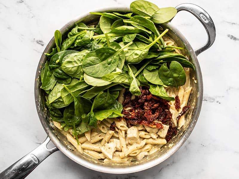 Spinach and sun dried tomatoes added to the skillet