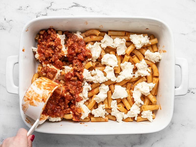 First layers of pasta, cheese, and sauce in the casserole dish