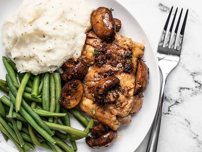 Close overhead view of Balsamic Chicken and Vegetables on a plate with mashed potatoes and green beans