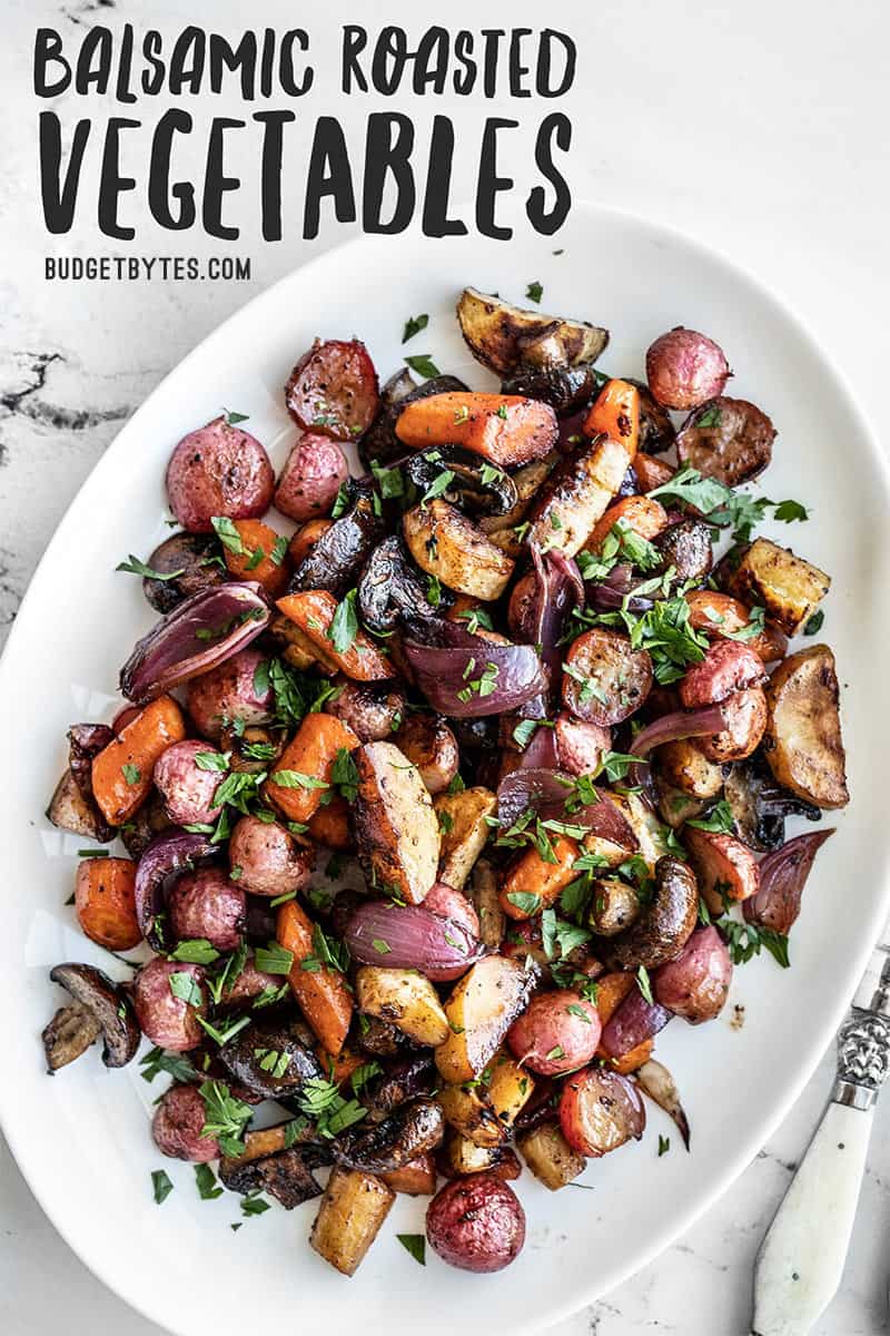 Balsamic roasted vegetables on a white platter, topped with chopped parsley. Title text overlay at the top.