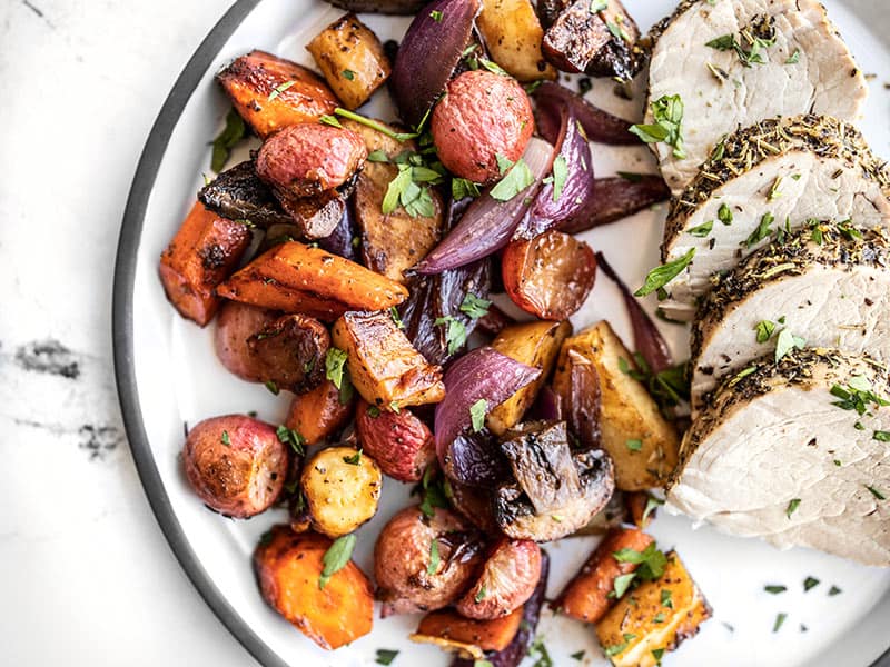 Balsamic roasted vegetables on a plate with roasted pork