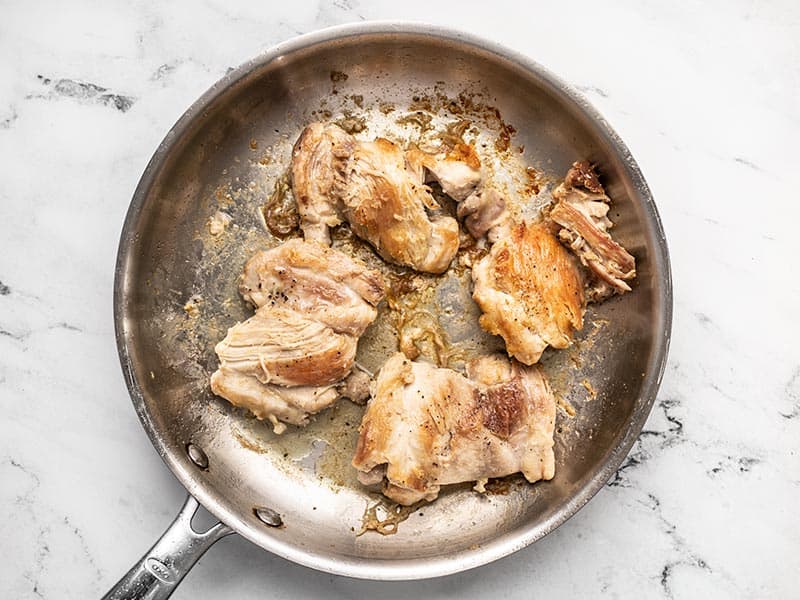 Browned chicken thighs in skillet