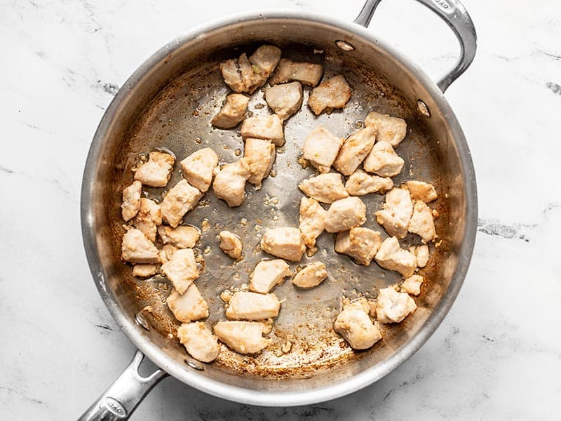 Browned chicken pieces in a deep skillet
