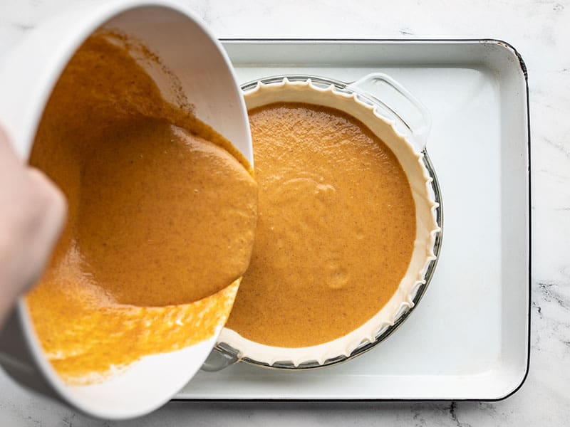 Pie filling being poured into a pie crust