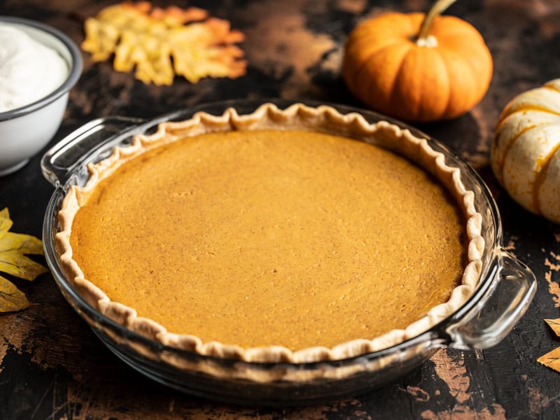 Baked Maple Brown Butter Pumpkin Pie with mini pumpkins in the background