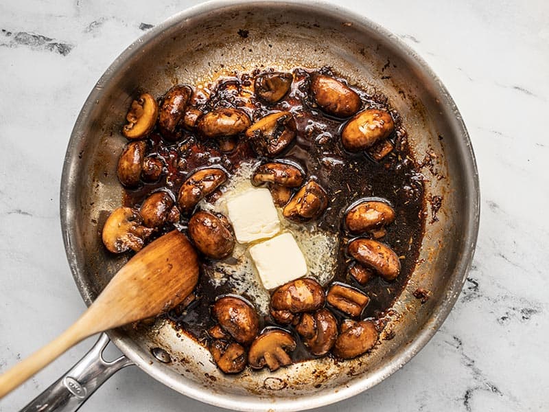 Butter melting into balsamic sauce in the skillet