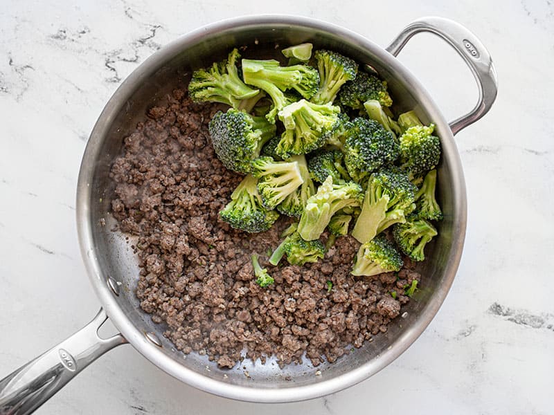 Frozen broccoli added to the skillet with beef