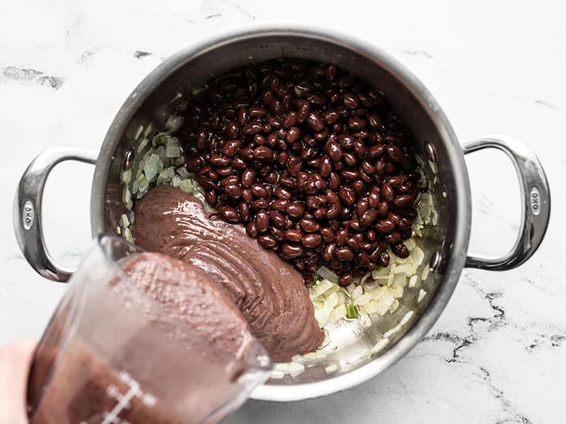 Add whole and puréed black beans to soup pot