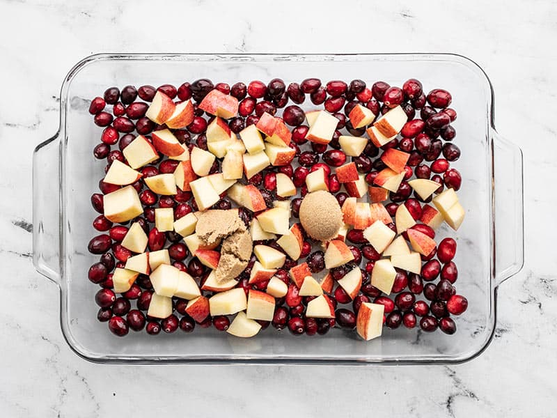 Chopped apples, cranberries, and brown sugar in baking dish