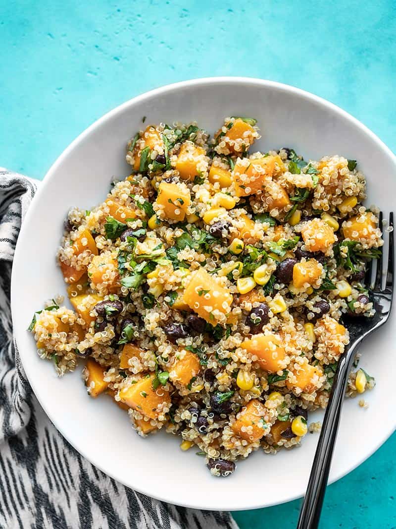 Overhead of a bowl of Chipotle Butternut Squash and Quinoa Salad with a black fork