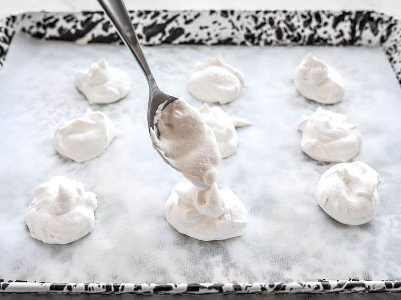 Whipped cream on lined baking sheet ready for freezing