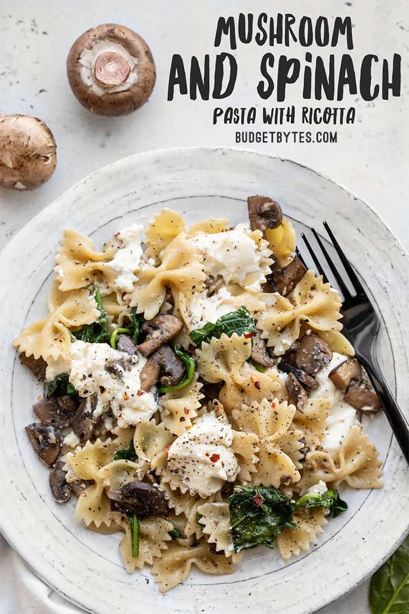 A plate full of Mushroom and Spinach Pasta with Ricotta with title text at the top right hand corner