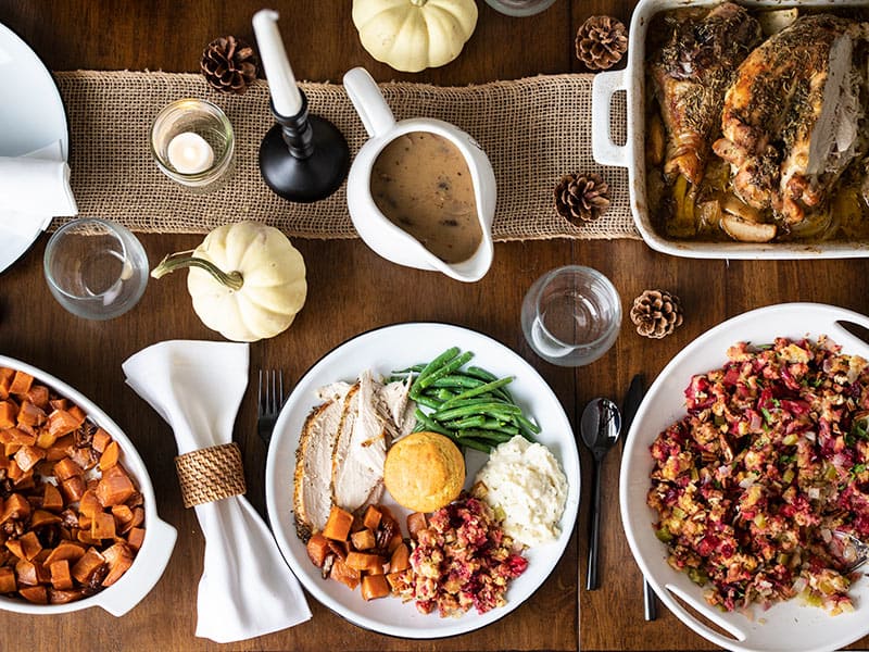 A full Thanksgiving dinner plate on a table with other Thanksgiving dishes