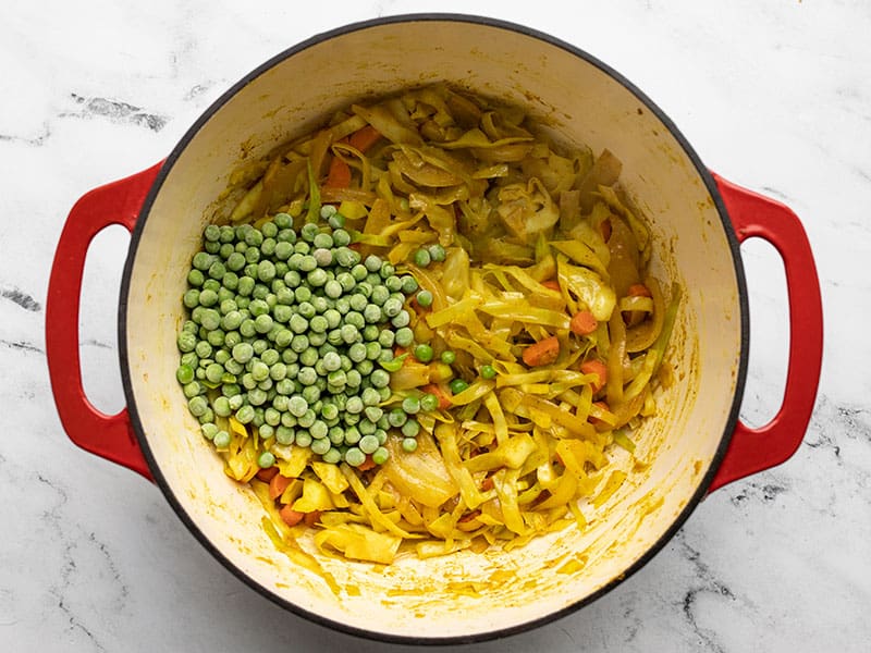 Add frozen peas to curried cabbage