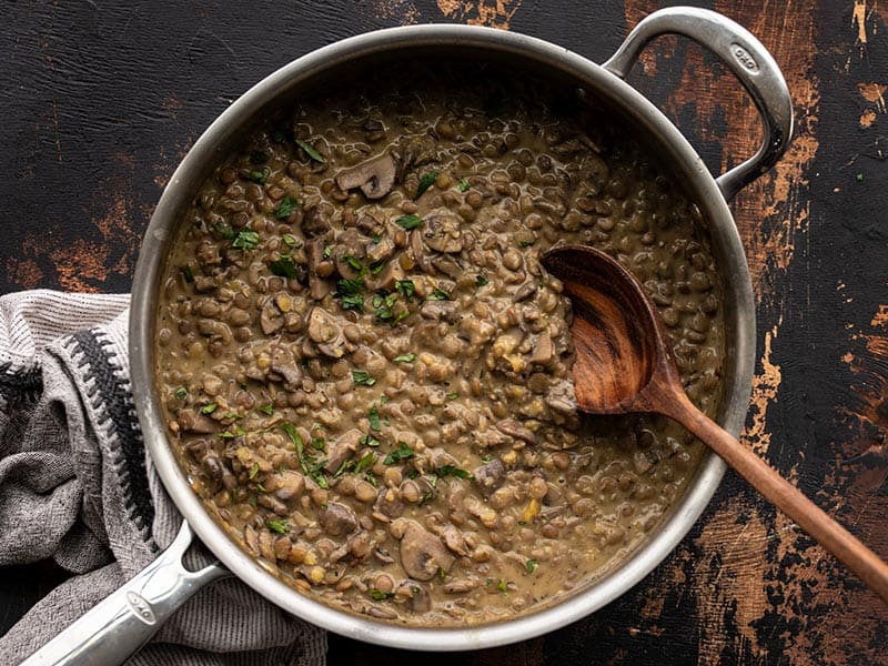 Finished lentils with creamy mushroom gravy garnished with parsley in the skillet