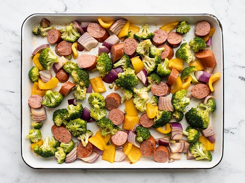 Seasoned sausage and vegetables on the baking sheet