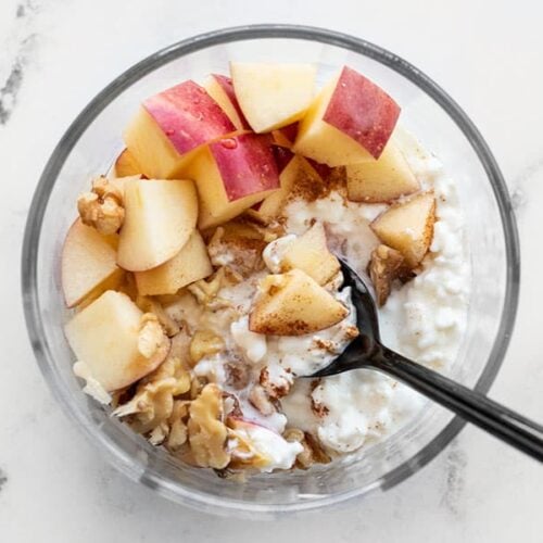 Close up overhead view of an Apple Cinnamon Cottage Cheese Breakfast Bowl in a glass meal prep container