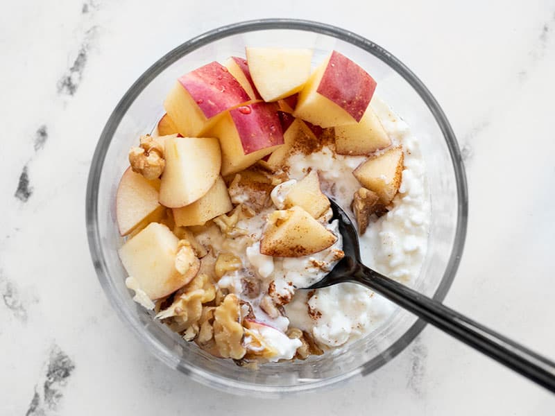 Close up overhead view of an Apple Cinnamon Cottage Cheese Breakfast Bowl in a glass meal prep container