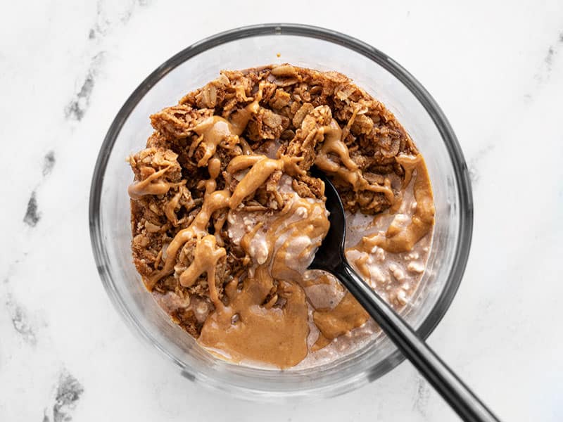 Chocolate flavored cottage cheese with peanut butter and granola in a glass bowl