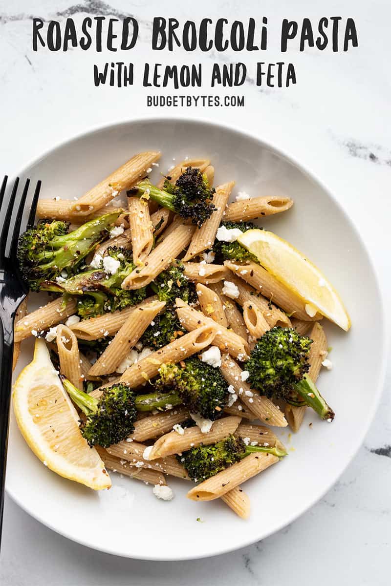 A bowl full of roasted broccoli pasta with lemon and feta with a fork on the side