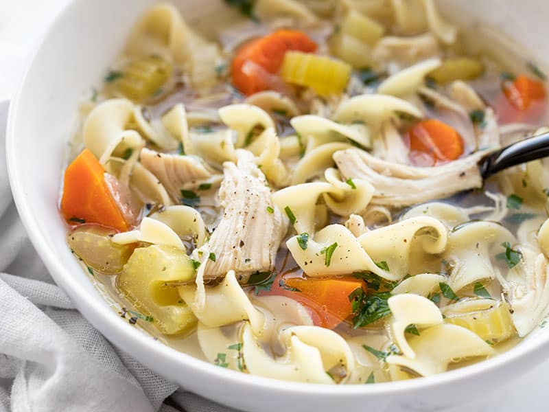 Close up side view of a bowl of slow cooker chicken noodle soup