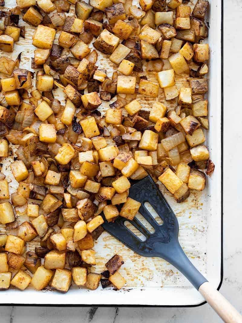 A sheet pan full of roasted breakfast potatoes with onions