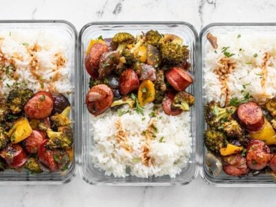 Three glass meal prep containers with rice and Smoky Roasted Sausage and Vegetables
