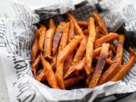 Close up side view of one bowl full of spicy sweet potato fries