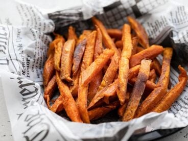 Close up side view of one bowl full of spicy sweet potato fries