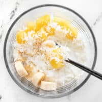 Cottage cheese, pineapple, banana, and coconut in a glass meal prep container