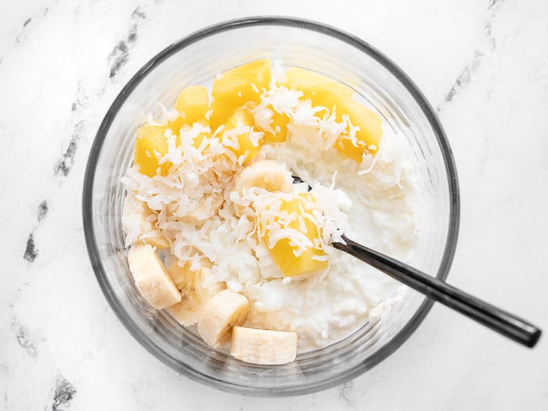 Cottage cheese, pineapple, banana, and coconut in a glass meal prep container