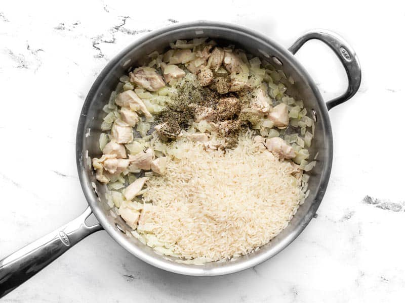 Cooked chicken in the skillet with rice and herbs