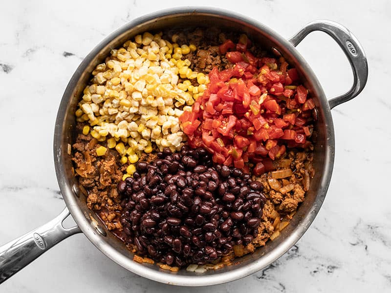 Black beans, tomatoes with green chiles, and corn added to the skillet