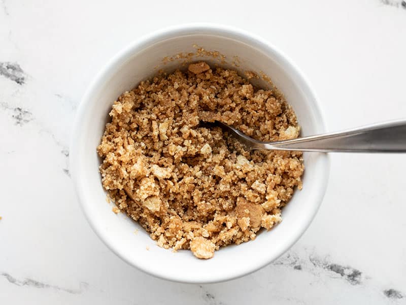 Graham cracker crust crumbs in a small bowl with butter and brown sugar