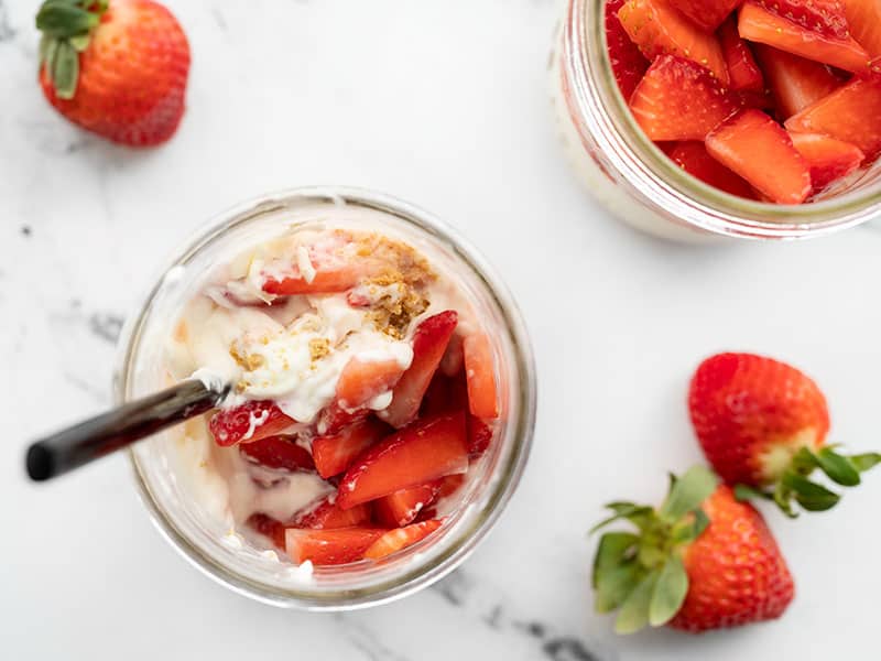 Overhead view of a half-stirred jar with no bake strawberry cheesecake
