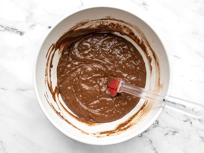Mixed cake batter in the bowl with a red spatula