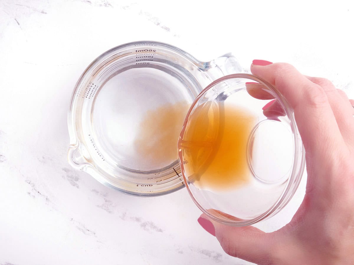 Vanilla extract being poured into water.