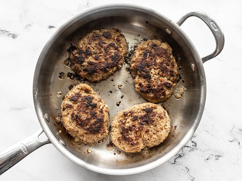 Cooked beef patties in a skillet