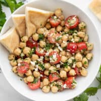 Overhead view of a bowl of Chimichurri Chickpea Salad with pita in the side of the bowl