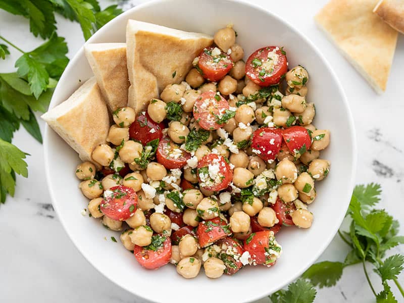 Overhead view of a bowl of Chimichurri Chickpea Salad with pita in the side of the bowl